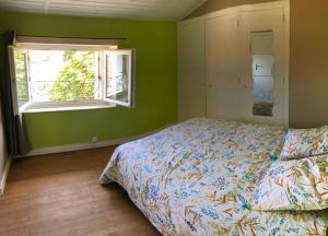 una camera con letto e finestra di Maison de vacances familiale au cœur du marais poitevin a Maillezais