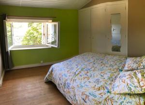a bedroom with a bed and a window at Maison de vacances familiale au cœur du marais poitevin in Maillezais