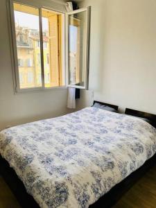 Schlafzimmer mit einem blauen und weißen Bett und einem Fenster in der Unterkunft 3 bedroom apartment with beautiful view old port in Marseille