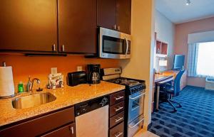 a kitchen with a sink and a microwave at TownePlace Suites by Marriott Baton Rouge Gonzales in Gonzales