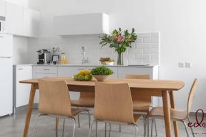 a kitchen with a wooden table and chairs with fruit on it at דירה משפחתית מפנקת 100 מטר מהים - By Edomlux in Eilat
