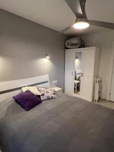 ein Schlafzimmer mit einem großen Bett und einem lila Kissen in der Unterkunft Palūšės Apartment in Palūšė