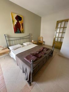 un grande letto in una camera da letto con un dipinto sul muro di Vista Do Mar Sea View WI-FI FREE Sal Rei a Sal Rei