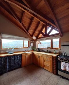 cocina grande con armarios y ventanas de madera en Tranquera's house en San Martín de los Andes