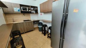 una cocina con nevera de acero inoxidable y armarios en Hotel Olas, en San Andrés