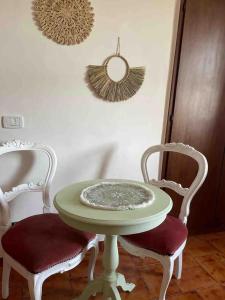una mesa verde con 2 sillas y 2 espejos en Ai piedi del castello, en Scurcola Marsicana
