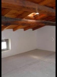 Habitación con techo de madera y pared blanca. en Ai piedi del castello, en Scurcola Marsicana