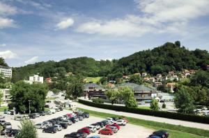 a parking lot filled with cars in front of a mountain at Apartman Dada in Krapinske Toplice