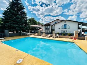 a large swimming pool in front of a house at Studio 6 Suites Flagstaff AZ in Flagstaff