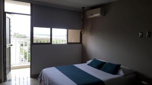 a bedroom with a bed with blue pillows and a window at Capilla Del Sol in Buenaventura +14 photos