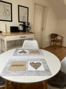 a white table in a room with a table with at Im Wald in Gleiszellen-Gleishorbach