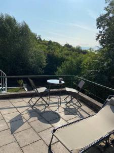 un patio con tavolo e sedie sul balcone. di Im Wald a Gleiszellen-Gleishorbach