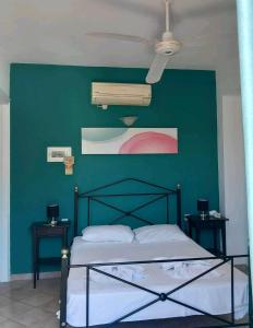 una camera da letto con una parete verde e un letto di Pansion Limni a Keríon