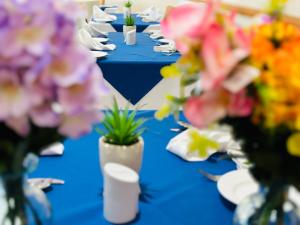 a row of blue tables with flowers in vases at Acorn Lodge Hotel Gatwick & Parking in Horley