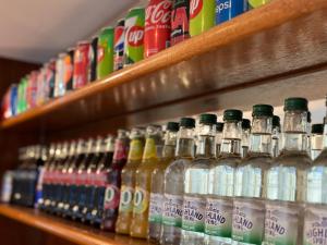 a row of bottles of soda on a shelf at Acorn Lodge Hotel Gatwick & Parking in Horley