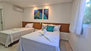 2 camas en una habitación con sábanas blancas en Porto Vila by AFT en Porto de Galinhas