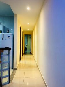 a hallway leading into a kitchen with a white refrigerator at Casa Amarela de Praia in Maricá