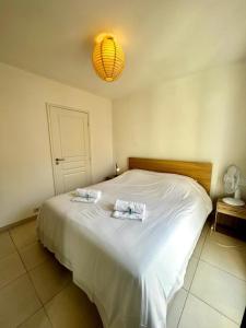 ein Schlafzimmer mit einem Bett mit zwei Handtüchern darauf in der Unterkunft Plaza Antibes one bedroom apartment with a parking spot in Antibes