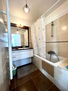 ein Badezimmer mit einer Badewanne, einem Waschbecken und einem Spiegel in der Unterkunft Plaza Antibes one bedroom apartment with a parking spot in Antibes