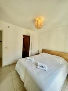 a bedroom with a white bed with two towels on it at Plaza Antibes one bedroom apartment with a parking spot in Antibes