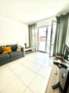 ein Wohnzimmer mit einem Sofa und einem Tisch in der Unterkunft Plaza Antibes one bedroom apartment with a parking spot in Antibes