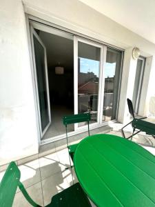 einen grünen Tisch und Stühle auf dem Balkon in der Unterkunft Plaza Antibes one bedroom apartment with a parking spot in Antibes