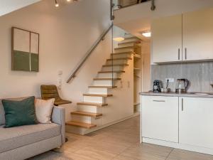 ein Wohnzimmer mit einem Sofa und einer Treppe in der Unterkunft TheServiced - Design Apartments in Stuttgart