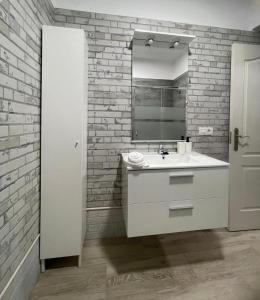 baño con lavabo blanco y pared de ladrillo en Vivienda Vacacional El Pajar, en Breña Alta
