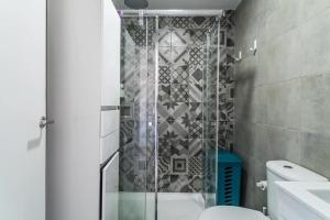 a bathroom with a shower with a toilet and a sink at Encantador Apartamento à frente da praia do Sunset in Figueira da Foz +13 photos