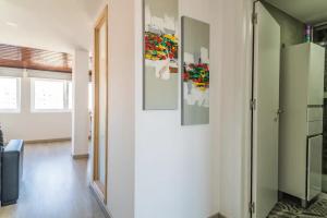 a hallway with three paintings on the wall at Encantador Apartamento à frente da praia do Sunset in Figueira da Foz