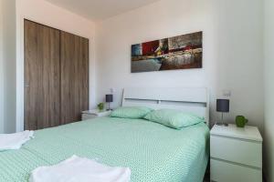 a bedroom with a bed with a green comforter at Encantador Apartamento à frente da praia do Sunset in Figueira da Foz