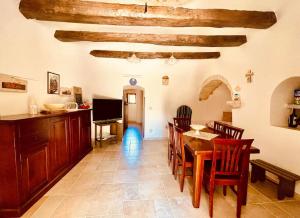 a kitchen and dining room with a table and chairs at Il trullo di Rosa in Impalata