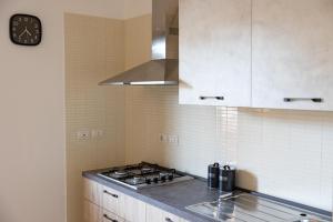 cocina con fogones y reloj en la pared en Chiaro di Luna Guest House, en Roccella Ionica