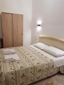 a bedroom with a large bed with white sheets and pillows at Casa Storico Centro in Marsala