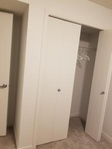 a closet with white cabinets in a room at Newcastle. A Place you can call home in Edmonton