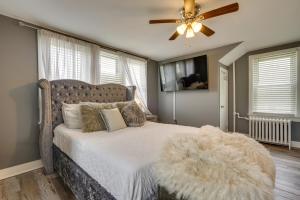 a bedroom with a bed with a white comforter and a ceiling fan at Atlantic City Getaway Near Casinos and Boardwalk! in Atlantic City