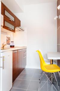 ウォムジャにあるPiękna Apartments Greyのキッチン(黄色の椅子、テーブル付)