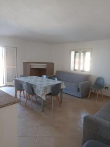 a living room with a table and a couch at Residenza Maria Antonia - Appartamento Francesco in Orosei