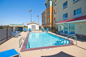 a swimming pool in front of a building at TownePlace Suites by Marriott Baton Rouge Gonzales in Gonzales
