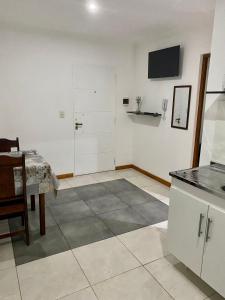 um quarto com uma cozinha com uma mesa e uma televisão em Santino Apart em Puerto Iguazú