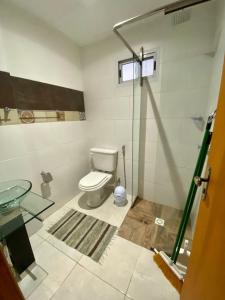 a bathroom with a toilet and a glass shower at Santino Apart in Puerto Iguazú