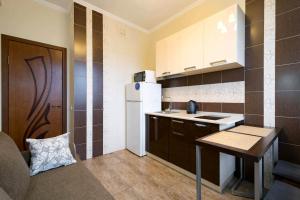 a small kitchen with a table and a refrigerator at Nadezhda Apartments on Kazybek bi st. in Almaty