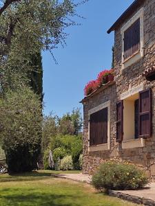 um antigo edifício de pedra com flores na janela em La Casa della Luna - Villa con piscina em Dolceacqua