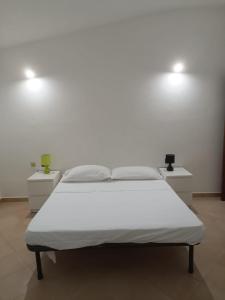 un letto in una camera con due luci sul muro di Residenza Maria Antonia - Appartamento Francesco a Orosei