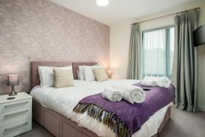 um quarto com uma cama grande e toalhas em Solar Sanctuary- Skyline Balcony, City Centre, Three Floors, King Beds, Netflix and more! em Bath