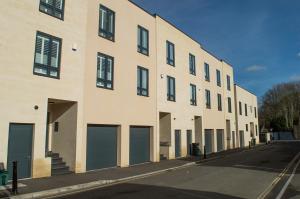 ein großes Gebäude mit vier Garagentüren auf einer Straße in der Unterkunft Solar Sanctuary- Skyline Balcony, City Centre, Three Floors, King Beds, Netflix and more! in Bath