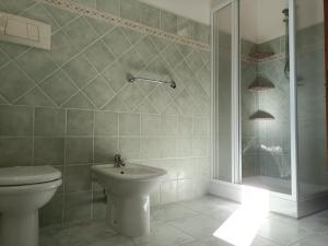 e bagno con servizi igienici, doccia e lavandino. di Residenza Maria Antonia - Appartamento Francesco a Orosei