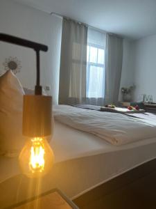 文登的住宿－Hotel Restaurant Zum Landmann，一间卧室配有一张带灯和窗户的床