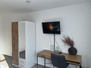 Habitación con escritorio y TV en la pared. en Hotel Restaurant Zum Landmann, en Wenden