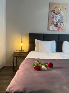 ein Schlafzimmer mit einem Bett mit zwei Rosen darauf in der Unterkunft Hotel Restaurant Zum Landmann in Wenden